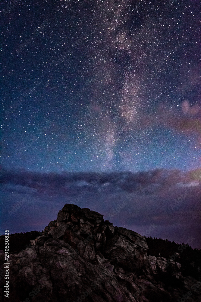 Milky Way galaxy in the night sky above rocky mountain