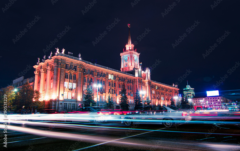 Naklejka premium Light trails of passing cars in front of Yekaterinburg city hall at night with dark sky