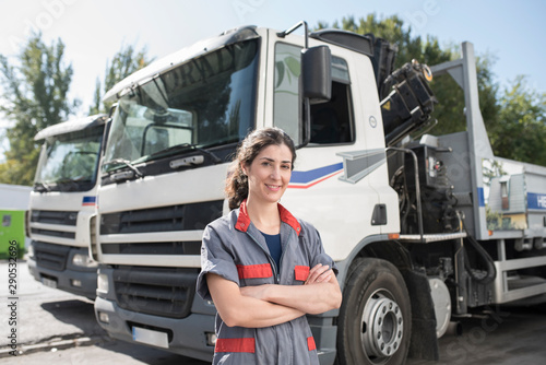 Constructuion woman worker near to iron structures transportation trucks
