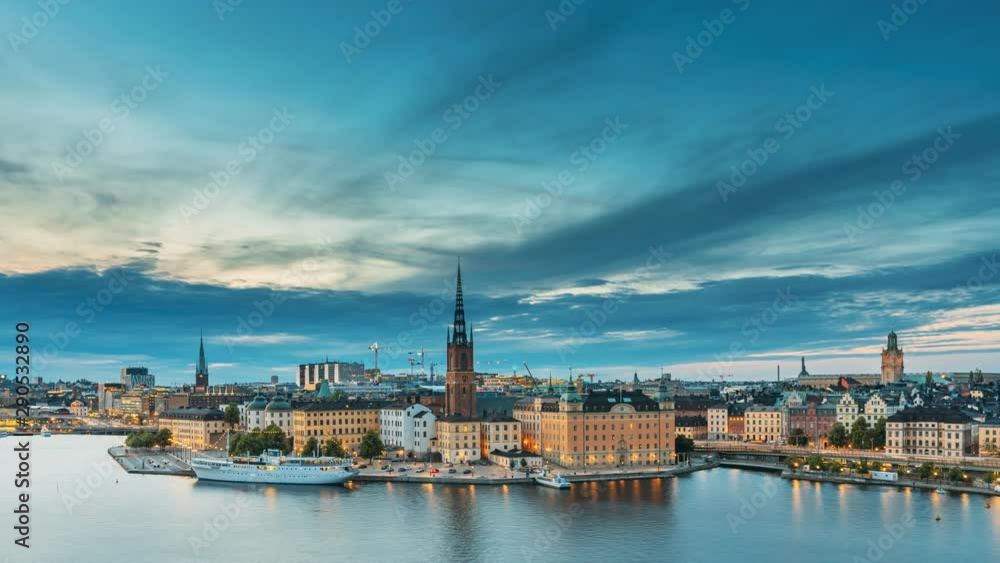 Stockholm, Sweden. Scenic View Of Stockholm Skyline At Summer Evening. Famous Popular Destination Scenic Place In Dusk Lights. Riddarholm Church In Day To Night Transition Time Lapse Stockholm, Sweden. Scenic View Of Stockholm Skyline At Summer Evening. Famous Popular Destination Scenic Place In Dusk Lights. Riddarholm Church In Day To Night Transition Time Lapse