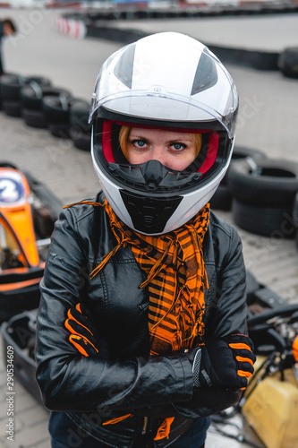 Portrait of a pretty girl wearing a white helmet close up, detail of Go-kart. karting track racing, copy space. serious look, determination, active lifestyle, extreme sport © Sergey