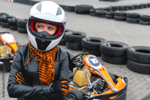 Portrait of a pretty girl wearing a white helmet close up, detail of Go-kart. karting track racing, copy space. serious look, determination, active lifestyle, extreme sport