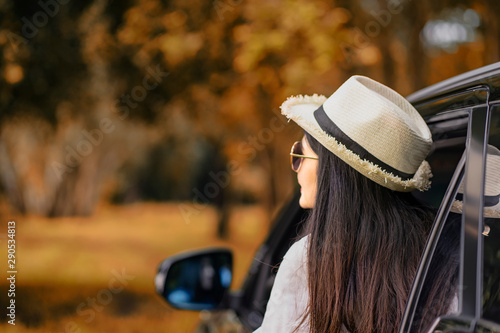 Asian women wearing hats sit in the car leans out of the car to see views.Woman traveling by car.Relax in the jungle.