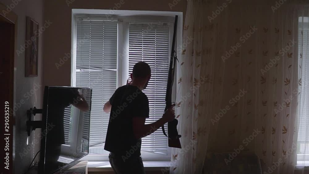 man with gun, looking through the window. bodyguard and self defense concept, otherwise robber, murderer and thief. man with gun, looking through the window. bodyguard and self defense concept, otherwise robber, murderer and thief.
