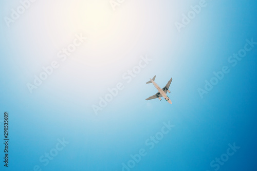 Fototapeta Naklejka Na Ścianę i Meble -  Airplane flying over the blue skies and sun rays. Travel concept.