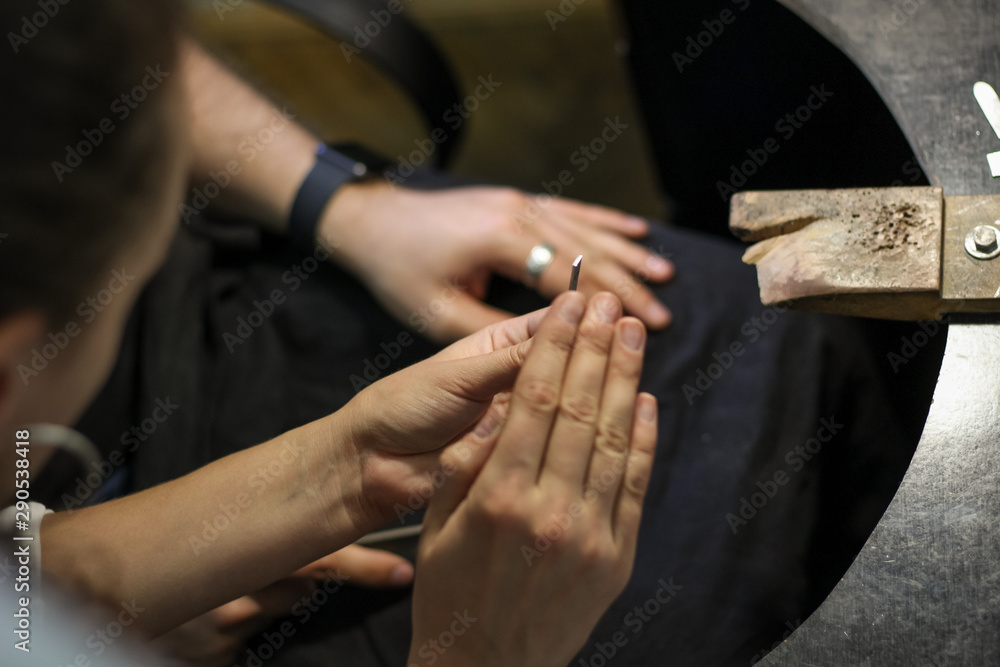 A jewelry master is working to create a silver ring