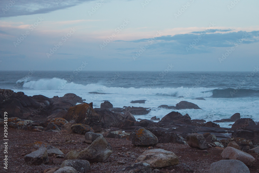 Atlantic Ocean coast in Portugal in the morning. Seascape in blue morning fog. Ocean beach with stones and waves. Empty beach. Rocky coastline. Wild nature concept. Atlantic Ocean coast in Portugal in the morning. Seascape in blue morning fog. Ocean beach with stones and waves. Empty beach. Rocky coastline. Wild nature concept.