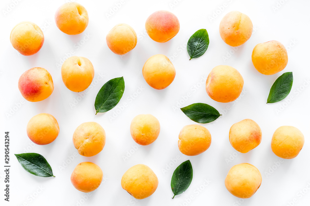 Apricots and leaves pattern on white top view - obrazy, fototapety, plakaty 