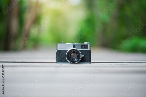 a retro camera on wooden plate in the forest 