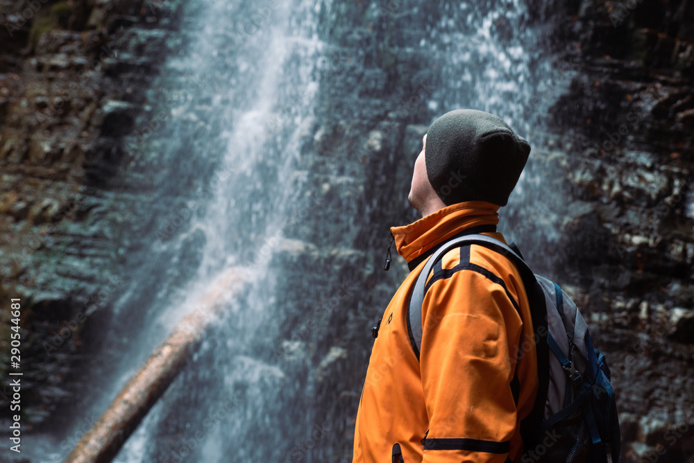 man hiking concept looking at waterfall in dip forest man hiking concept looking at waterfall in dip forest