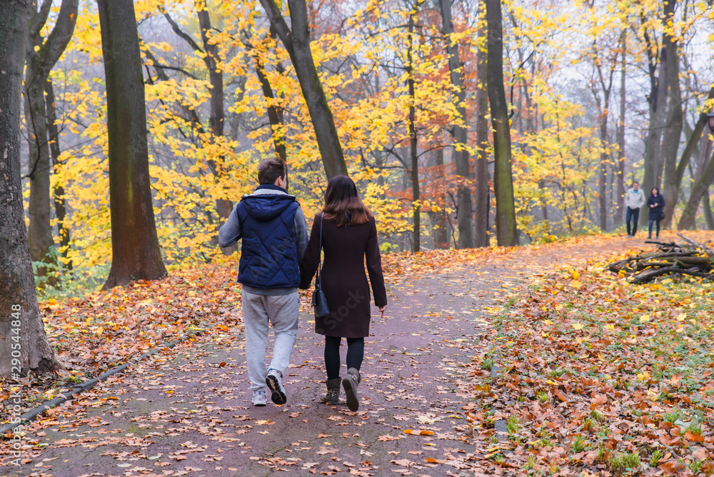 couple walking by autumn park fall season
