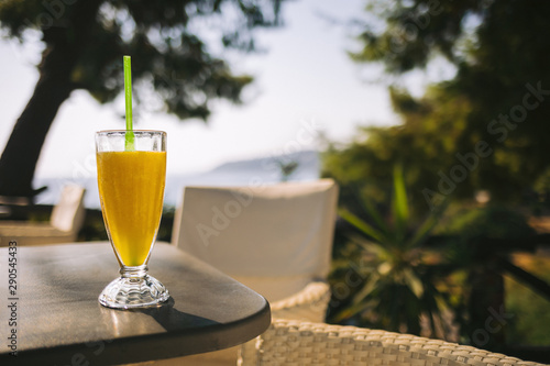 glass of fresh orange juice on the table in summer cafe