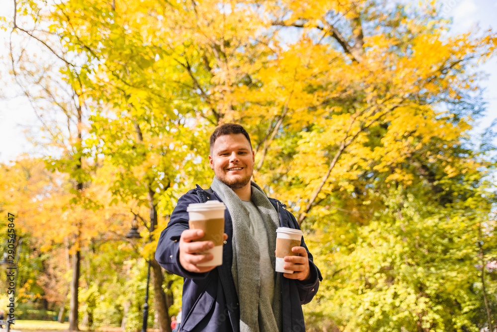 man brings coffee to friend drink to go outdoors autumn city park man brings coffee to friend drink to go outdoors autumn city park
