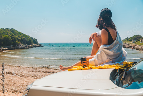 happy woman at sea summer beach sitting at car hood © phpetrunina14