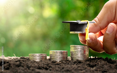 Graduation cap on coins, investment concept for education.