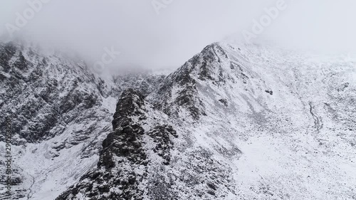 Foggy mountain peak in winter, aerial