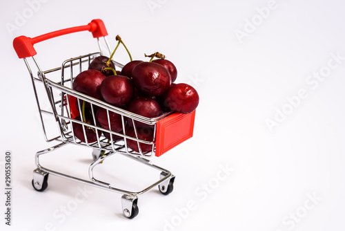 Shopping cart full of ripe cherries, healthy and nutritious shopping full of vitamins to feed children with fruits.