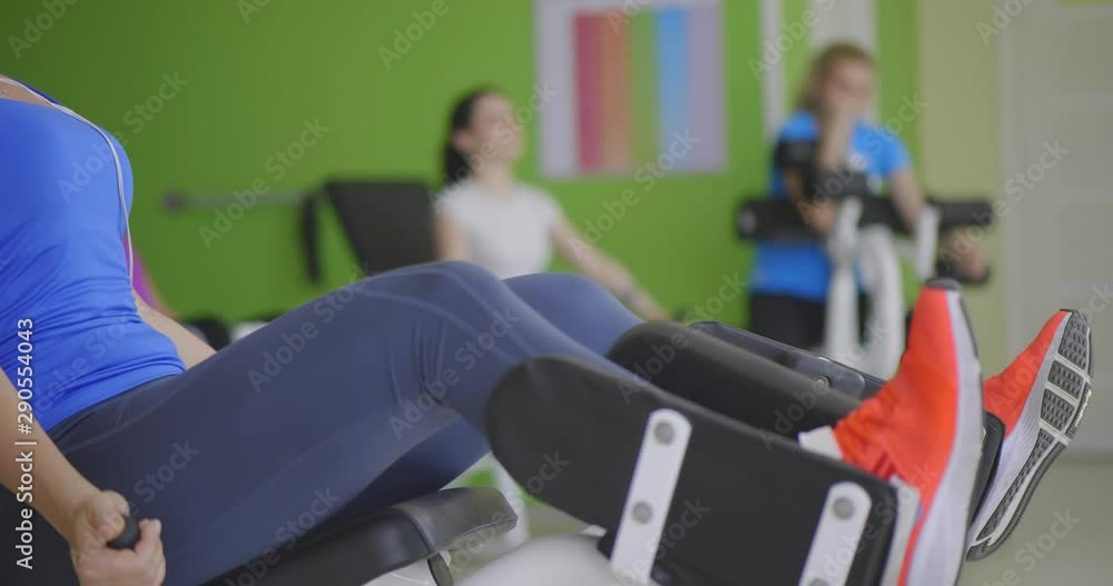 Senior woman does exercises for legs on training apparatus Senior woman does exercises for legs on training apparatus