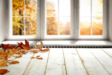 White wooden desk and autumn window space 