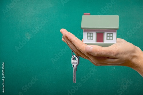 Businessman Holding House Model and Keys  Real Estate Concept