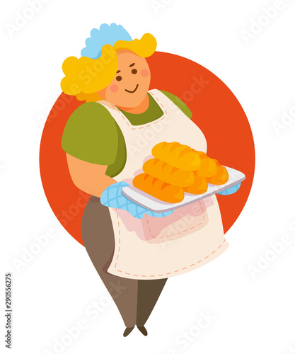 Cute lady baker holding a tray of freshly baked bread, smiling. 