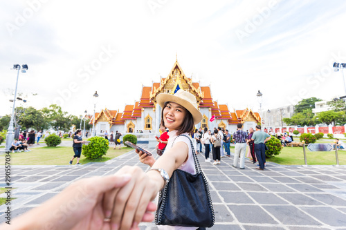 Asian smiling women leading hand to man travel in buddha temple © themorningglory
