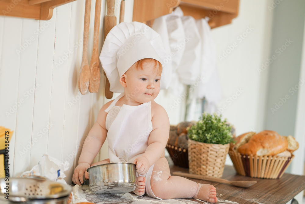 little baker child in chef hat at kitchen table alone little baker child in chef hat at kitchen table alone