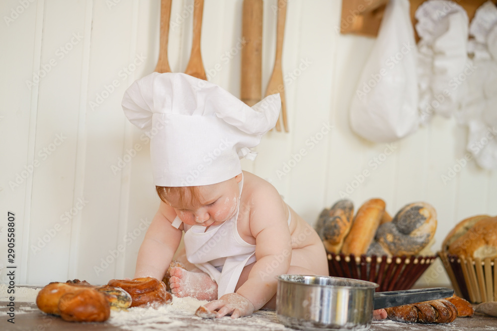 little baker child in chef hat at kitchen table alone little baker child in chef hat at kitchen table alone