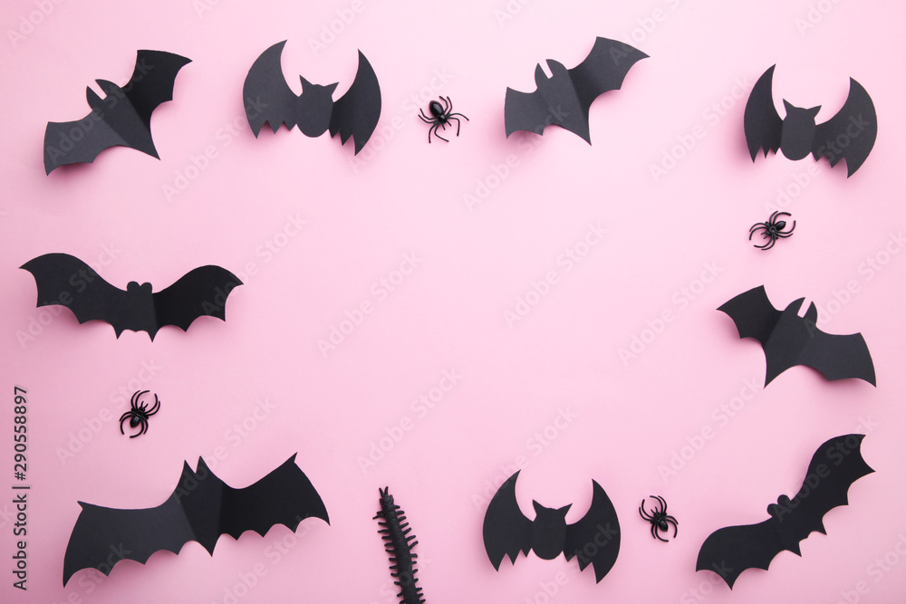 Halloween paper bats with spiders on pastel pink background. Halloween concept