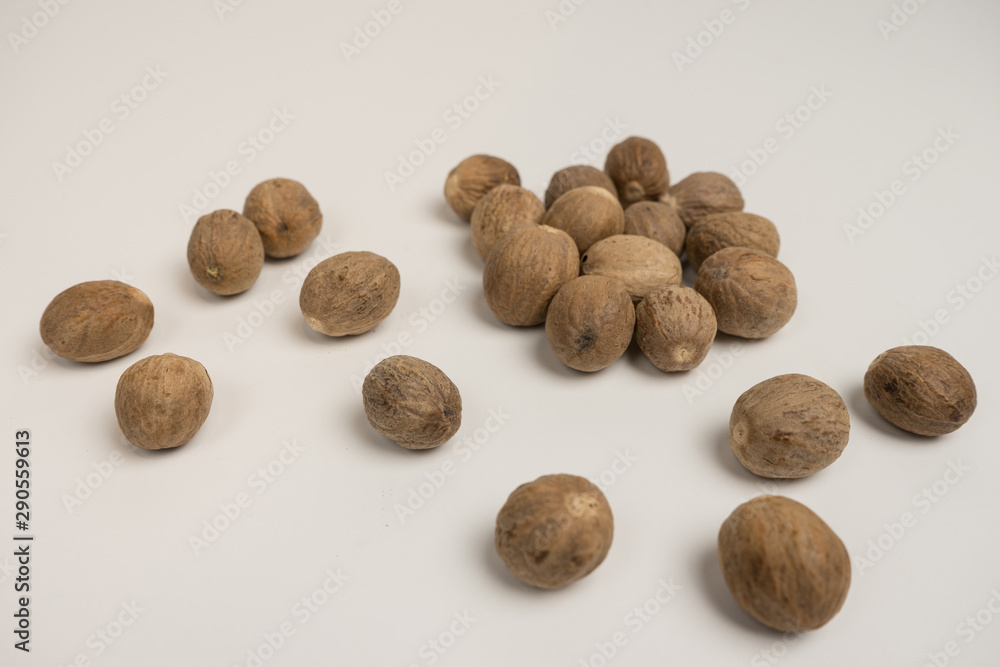 Loose nutmeg on a white plate and plate Loose nutmeg on a white plate and plate