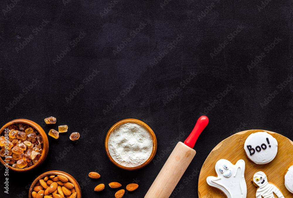 spooky halloween figures with rolling pin, flour, sugar, almond for cooking treat on black background top view mock up spooky halloween figures with rolling pin, flour, sugar, almond for cooking treat on black background top view mock up