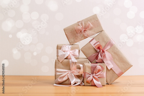 set of beautiful different gift boxes made by handmade with pink bows on a wooden table with a light background. flat lay