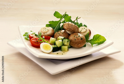 Plated Egg and Brown Mushroom Salad on white wood background
