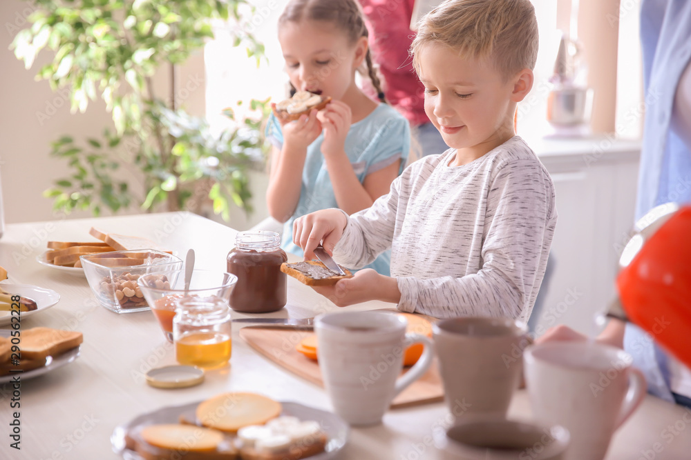 Little children having breakfast with toasts in kitchen Little children having breakfast with toasts in kitchen