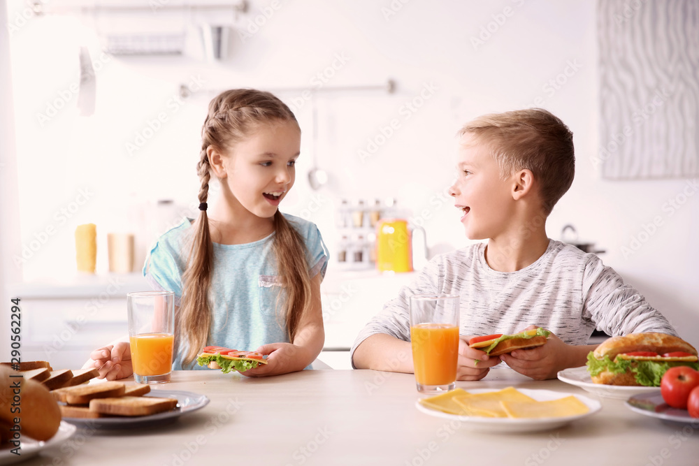 Little children having breakfast with toasts in kitchen Little children having breakfast with toasts in kitchen