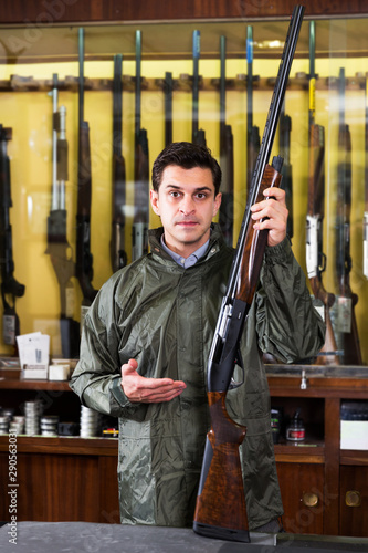Man choosing rifle in shop