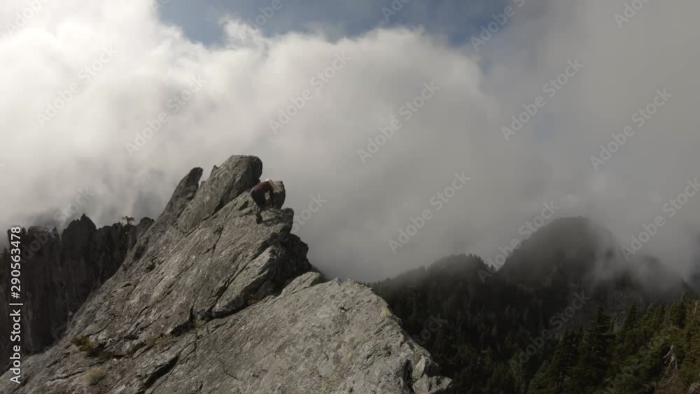 Adventurous Girl on top of a rugged rocky mountain during a cloudy summer morning. Taken on Crown Mountain, North Vancouver, BC, Canada. Adventurous Girl on top of a rugged rocky mountain during a cloudy summer morning. Taken on Crown Mountain, North Vancouver, BC, Canada.