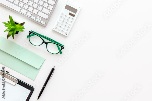 Creative work desk with green supplies on white background flat lay copy space top view