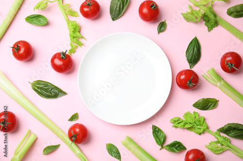 Flat lay composition with fresh salad ingredients on pink background, space for text
