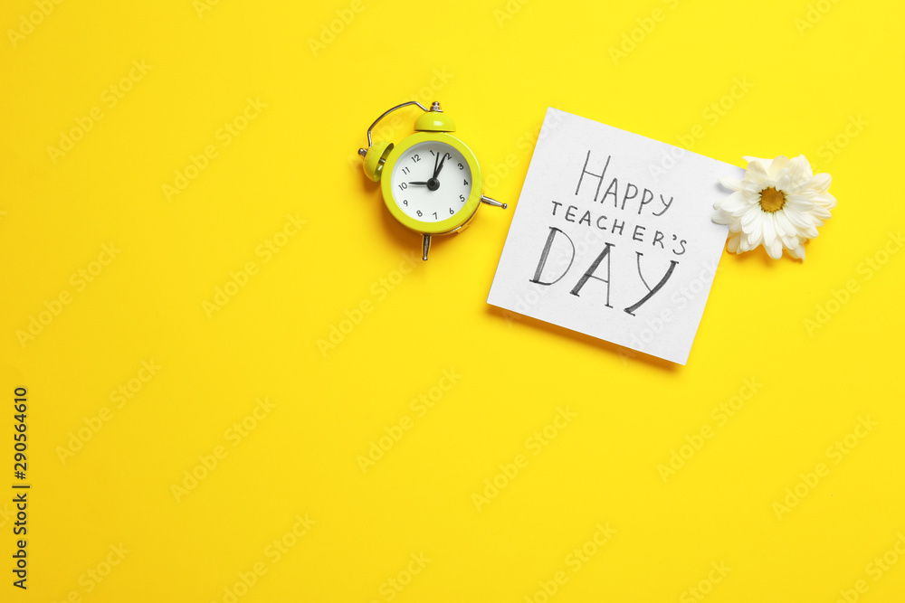 Flat lay composition of card with inscription HAPPY TEACHER'S DAY, flower and alarm clock on yellow background, space for text Flat lay composition of card with inscription HAPPY TEACHER'S DAY, flower and alarm clock on yellow background, space for text