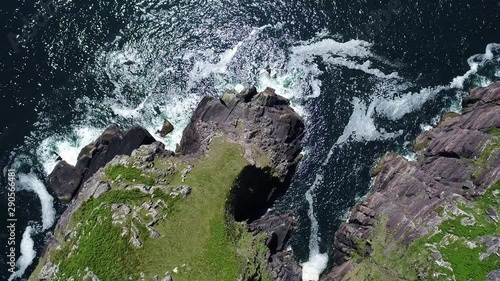 Waves crash on Irish coastline, overhead aerial