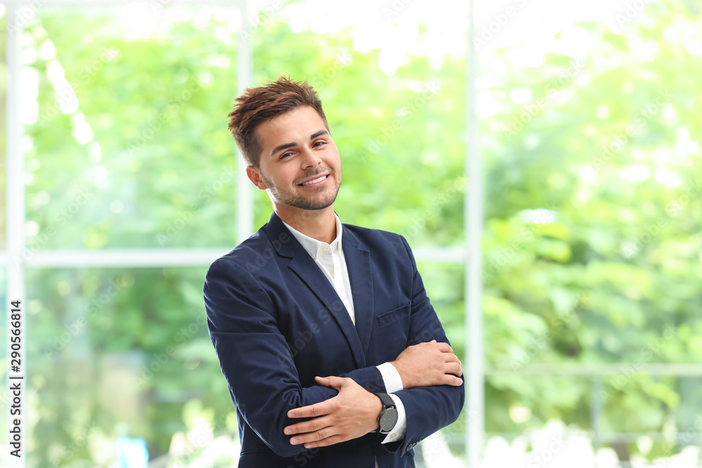 Portrait of handsome young man in elegant suit against window Portrait of handsome young man in elegant suit against window