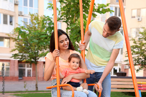 Happy family with adorable little baby at playground