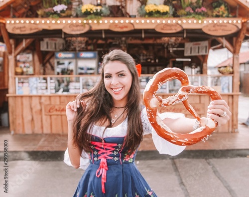 Portrait of woman wearing traditional Bavarian dress holding pretzel photo