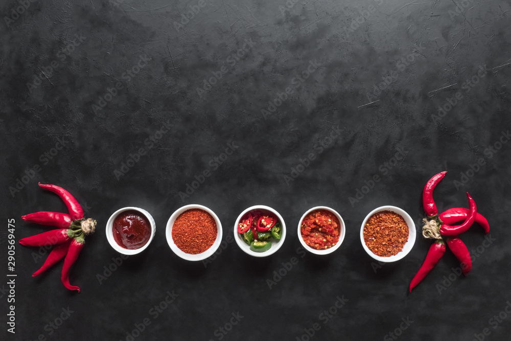 Various products of red hot pepper are laid out on a black background. Various products of red hot pepper are laid out on a black background.