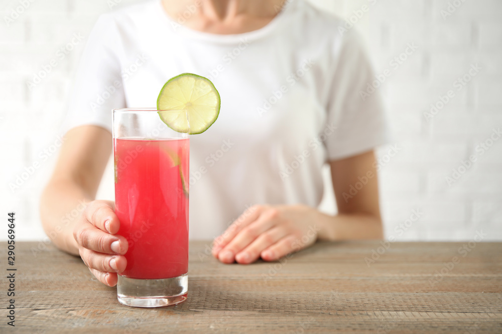 Young woman with glass of tasty refreshing drink at wooden table, closeup Young woman with glass of tasty refreshing drink at wooden table, closeup