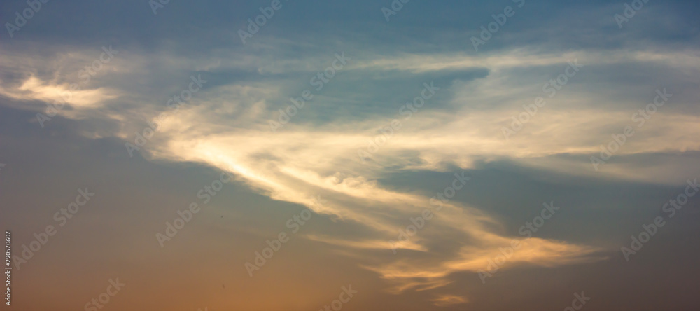 Obraz premium Clouds that are shaped like dragons flying in the sky or S form, at sunset background.