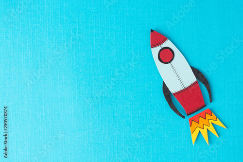 Start up business concept. Boost or increase incomes, salary. Drawn rocket on colorful blue background. Copy space. photo