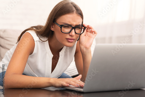 Girl Looking At Laptop Having Eyesight Problem At Home photo