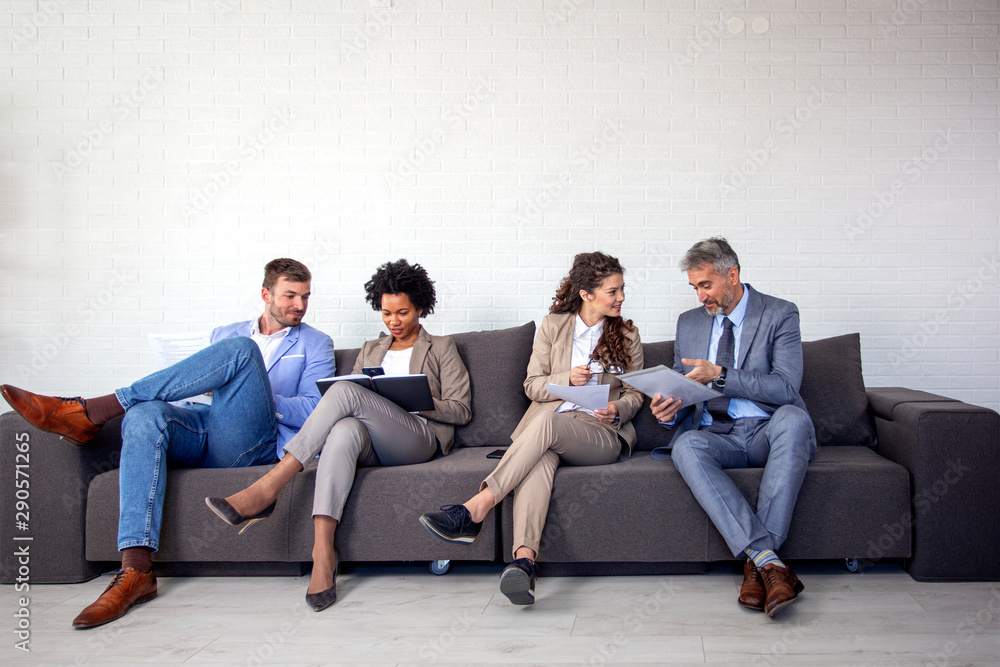 Group of four business people sitting on sofa Group of four business people sitting on sofa